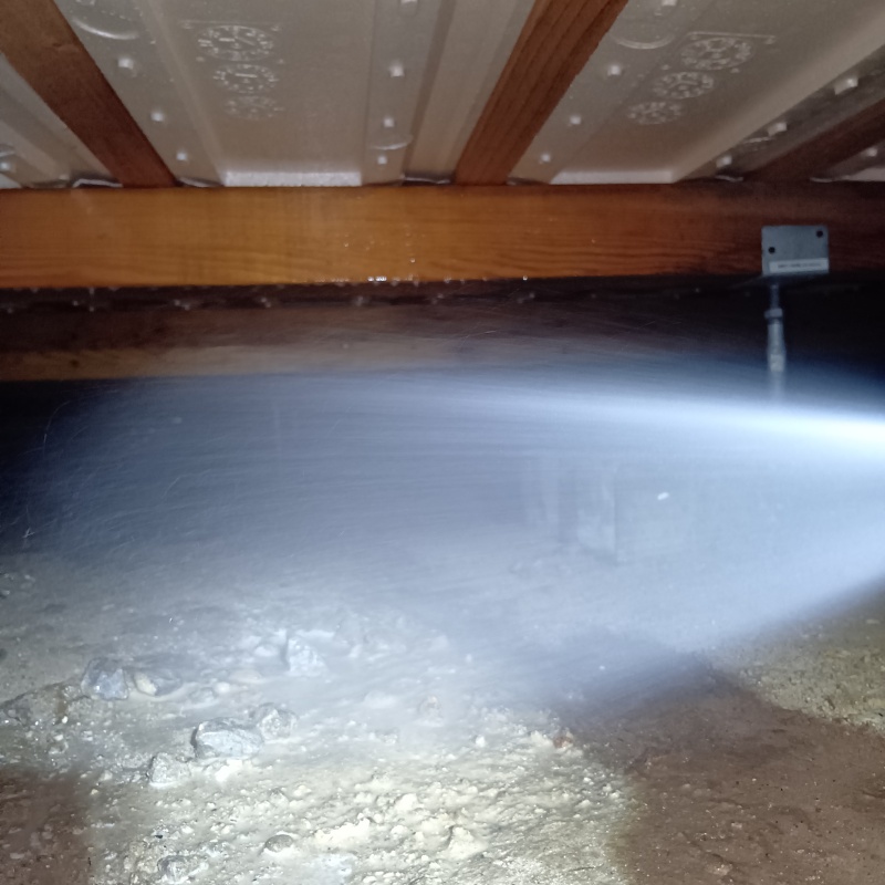 床下の土壌にシロアリ駆除剤を散布する様子