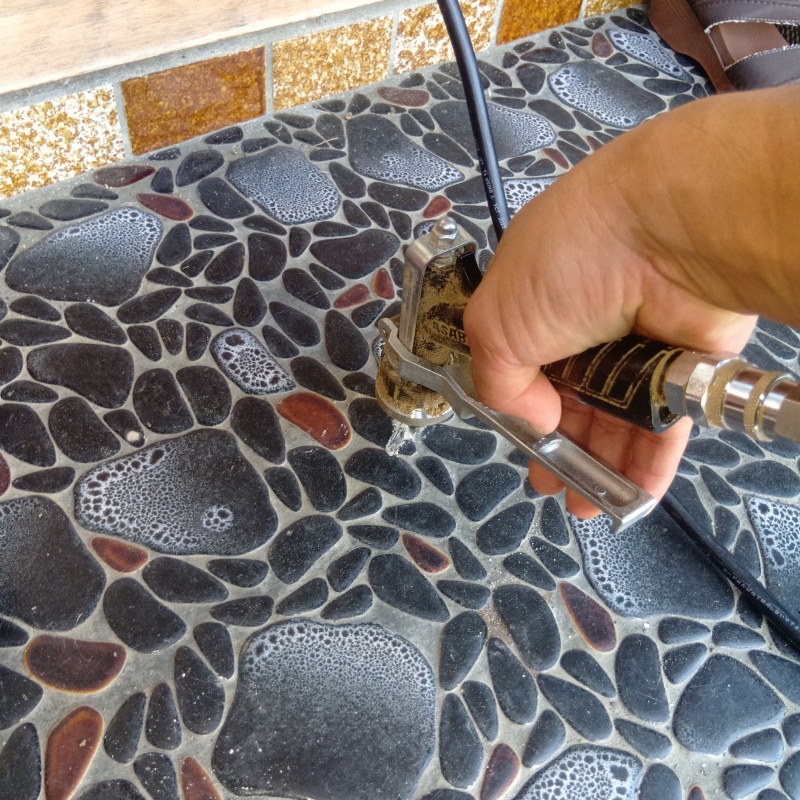 玄関の床にシロアリ駆除剤を注入する様子