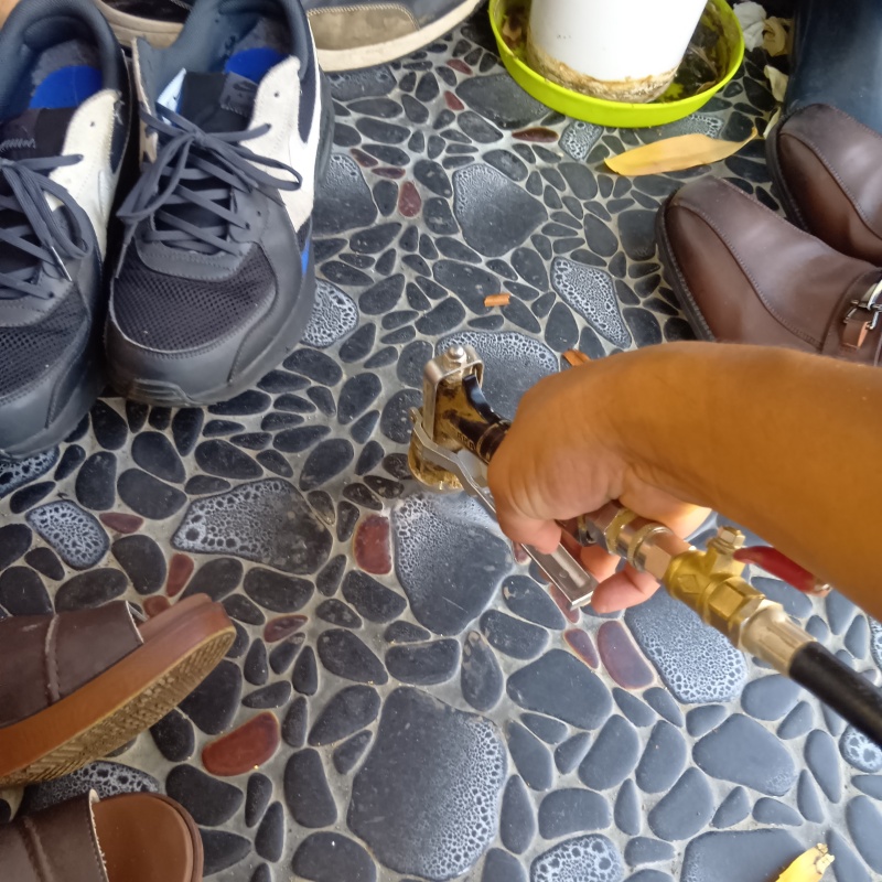 玄関の床にシロアリ駆除剤を注入する様子