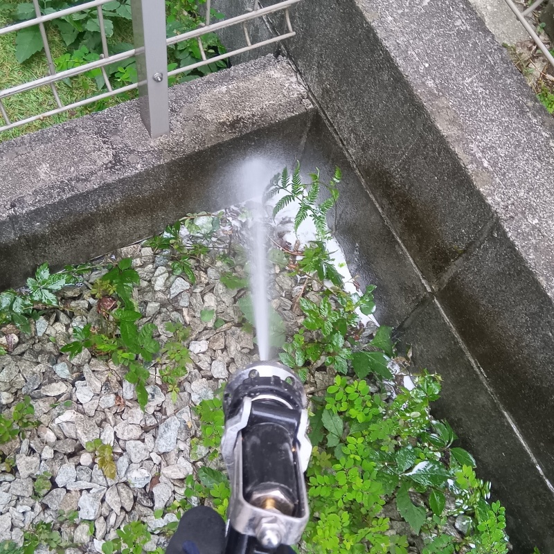 塀の周りに防蟻剤を散布する様子