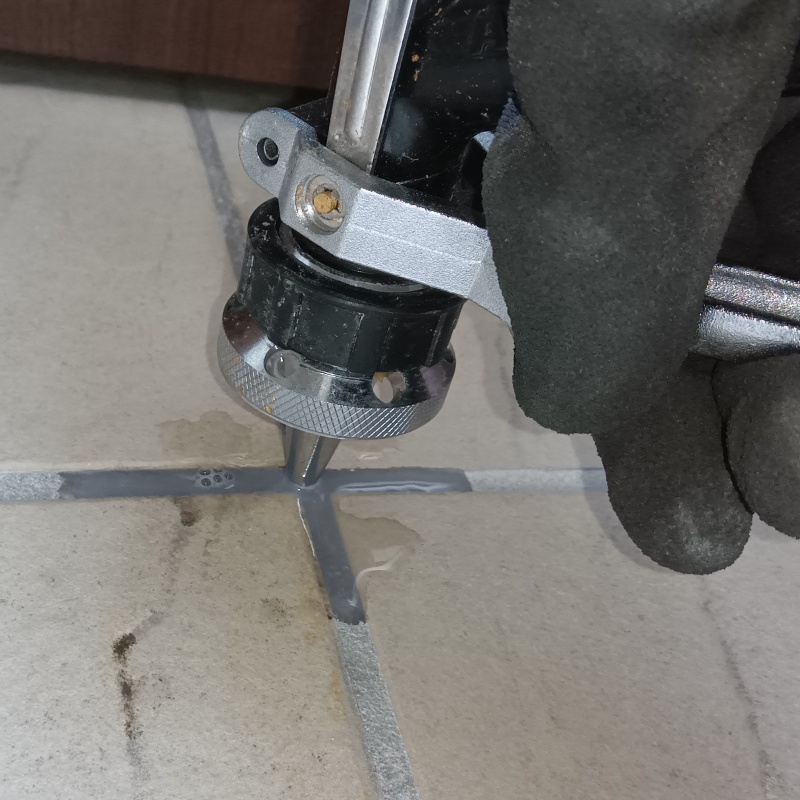 玄関の床に防蟻剤を注入する様子