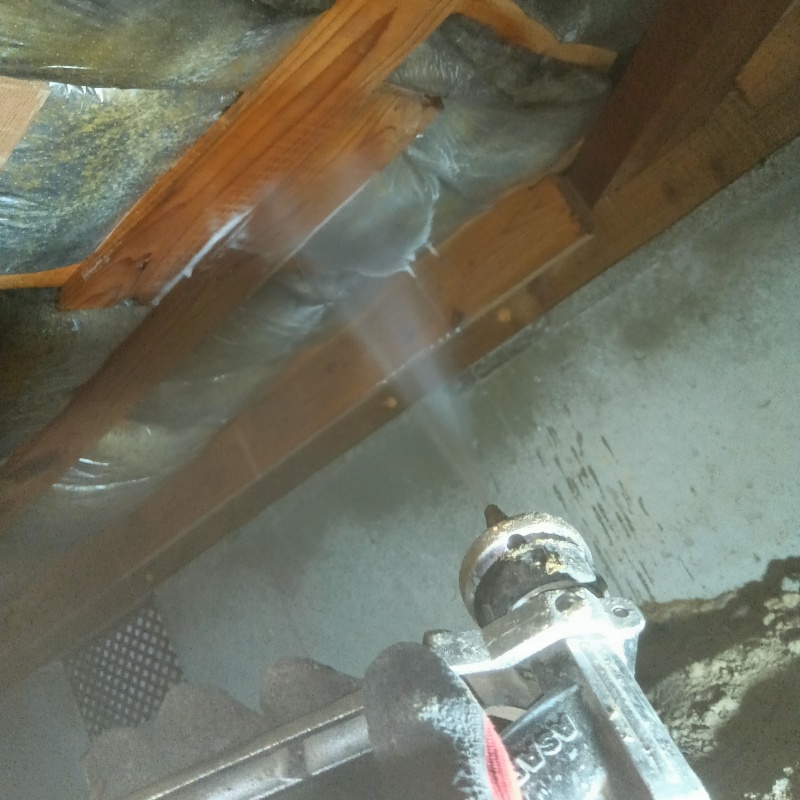 床下の木材と断熱材に防蟻剤を散布する様子