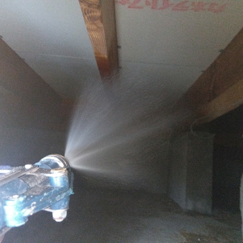 床下の木材と断熱材にシロアリ駆除剤を散布する様子