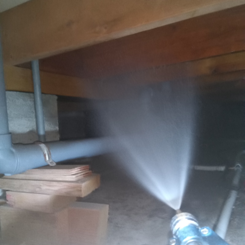 床下の木材にシロアリ駆除剤を散布する様子