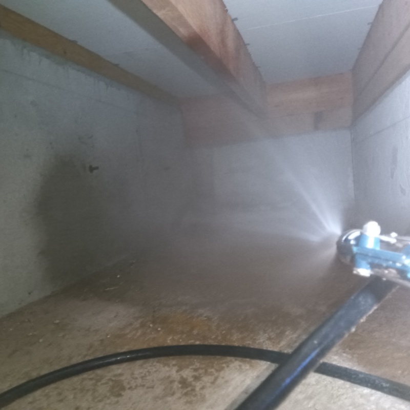 床下の基礎部分にシロアリ駆除剤を散布する様子