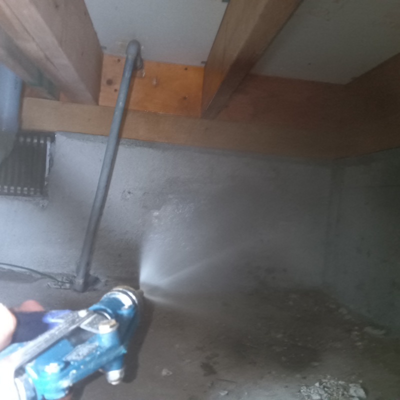 床下の基礎部分にシロアリ駆除剤を散布する様子