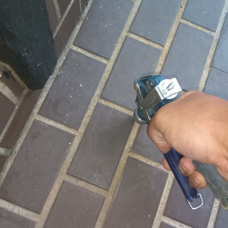 玄関の床にシロアリ駆除剤を注入する様子