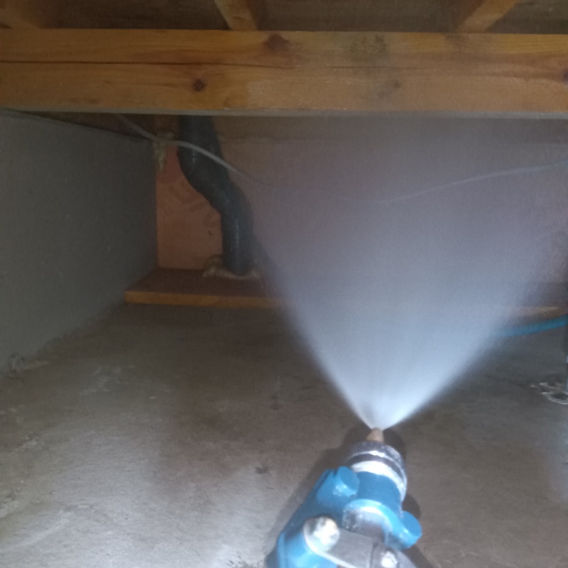 床下の木材に防蟻剤を散布する様子