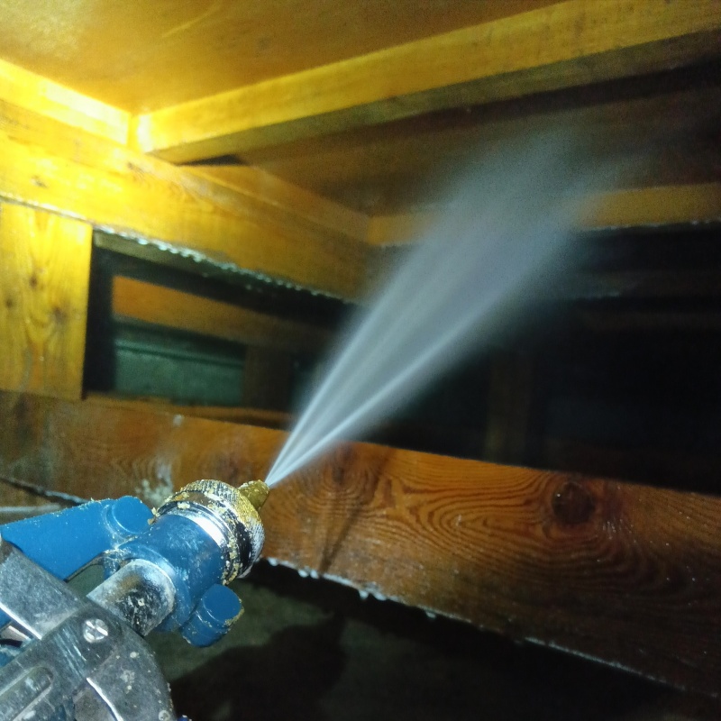 床下の木材にシロアリ駆除剤を散布する様子