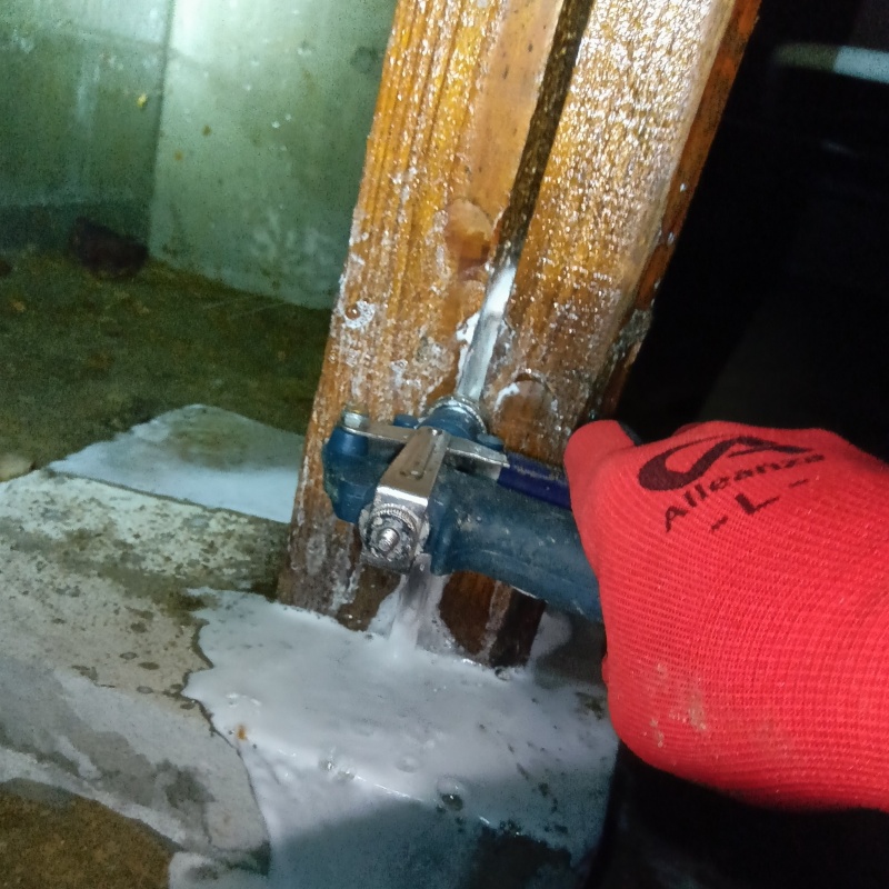 食害を受けた床下の木材にシロアリ駆除剤を散布する様子