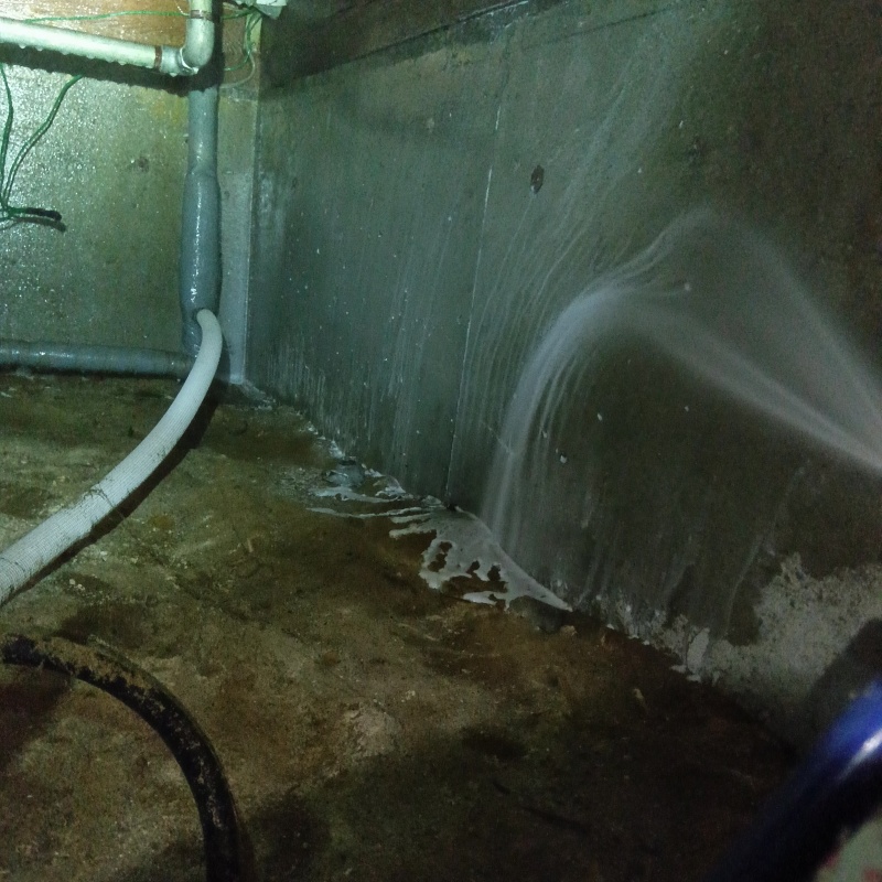 床下の基礎部分にシロアリ駆除剤を散布する様子