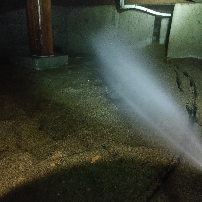 床下の土壌にシロアリ駆除剤を散布する様子