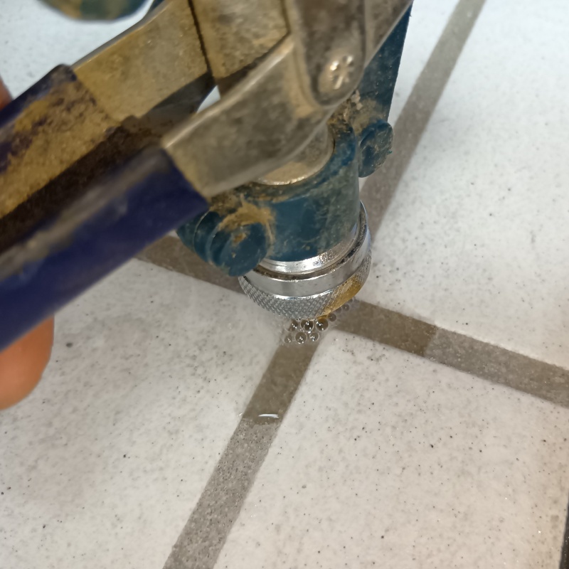 玄関の床にシロアリ駆除剤を注入する様子