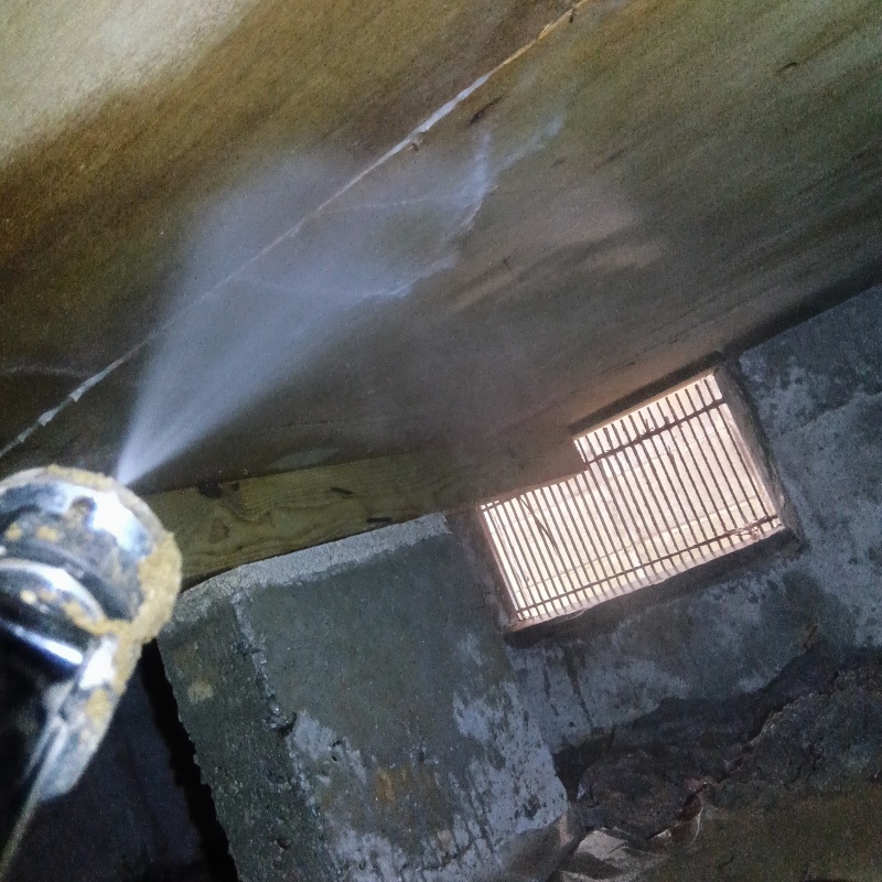 床下の木材にシロアリ駆除剤を散布する様子