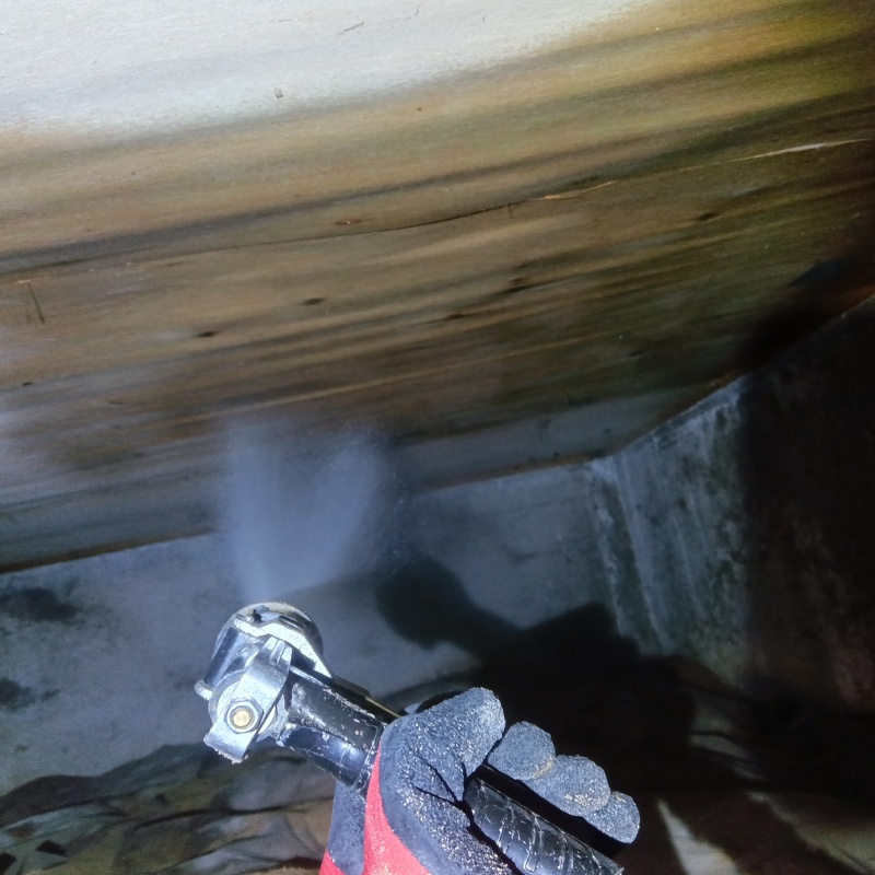 床下の木材にシロアリ駆除剤を散布する様子