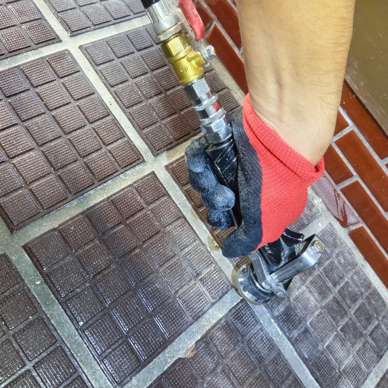 玄関の床にシロアリ駆除剤を注入する様子