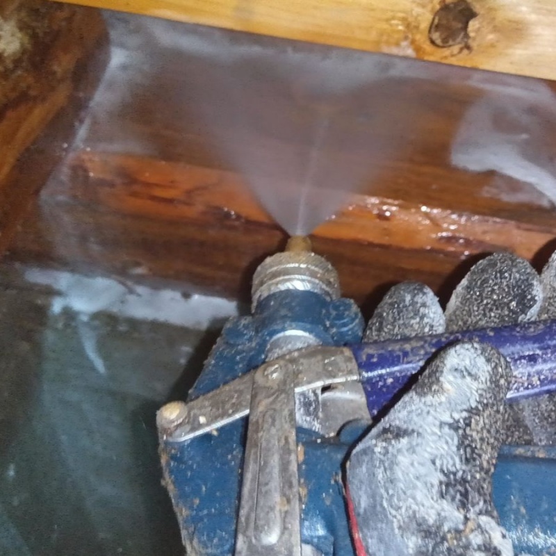 床下の木材にシロアリ駆除剤を散布する様子