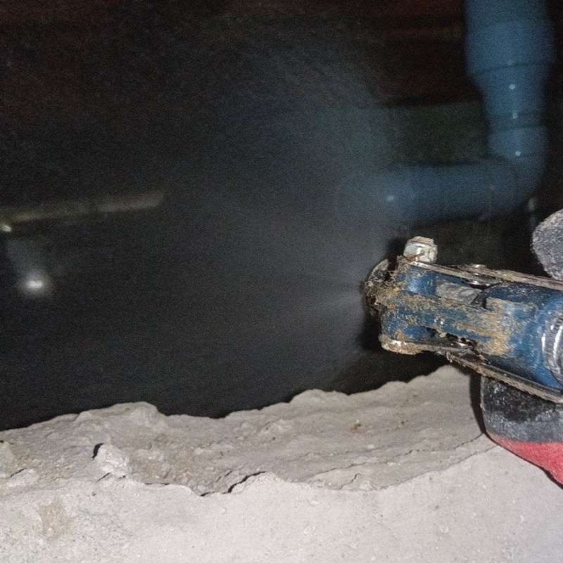 床下の土壌にシロアリ駆除剤を散布する様子