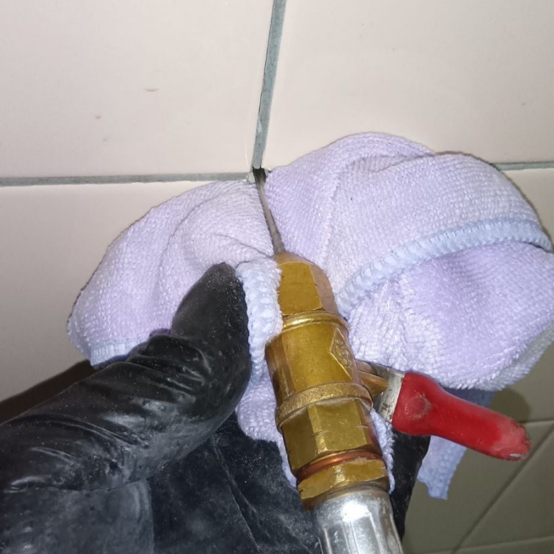 浴室の壁にシロアリ駆除剤を注入する様子