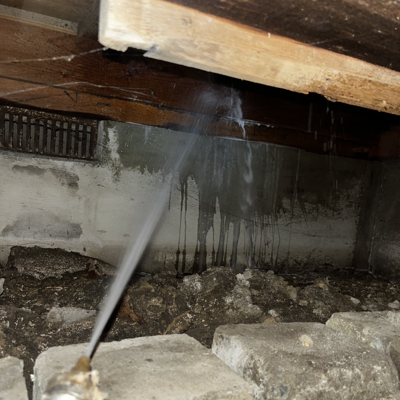 床下の木材にシロアリ駆除剤を散布する様子