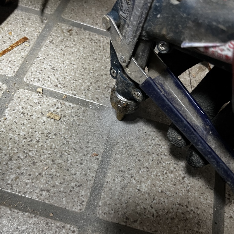 玄関の床にシロアリ駆除剤を注入する様子