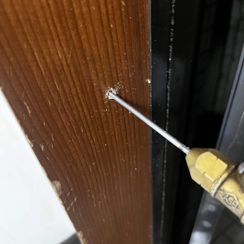 玄関の柱にシロアリ駆除剤を注入する様子