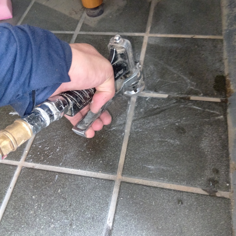 玄関の床にシロアリ駆除剤を注入する様子