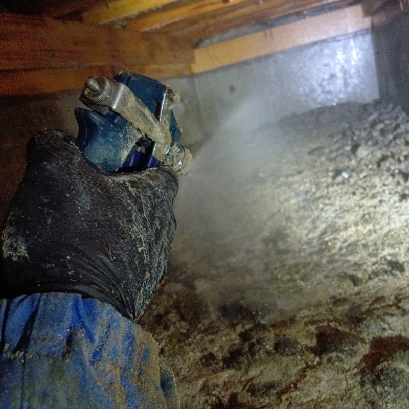 床下の土壌にシロアリ駆除剤を散布する様子