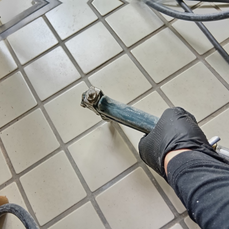 玄関の床にシロアリ駆除剤を注入する様子