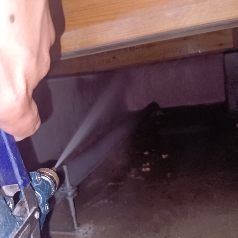 床下の基礎部分に防蟻剤を散布する様子