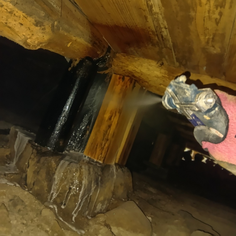 床下の木材にシロアリ駆除剤を散布する様子