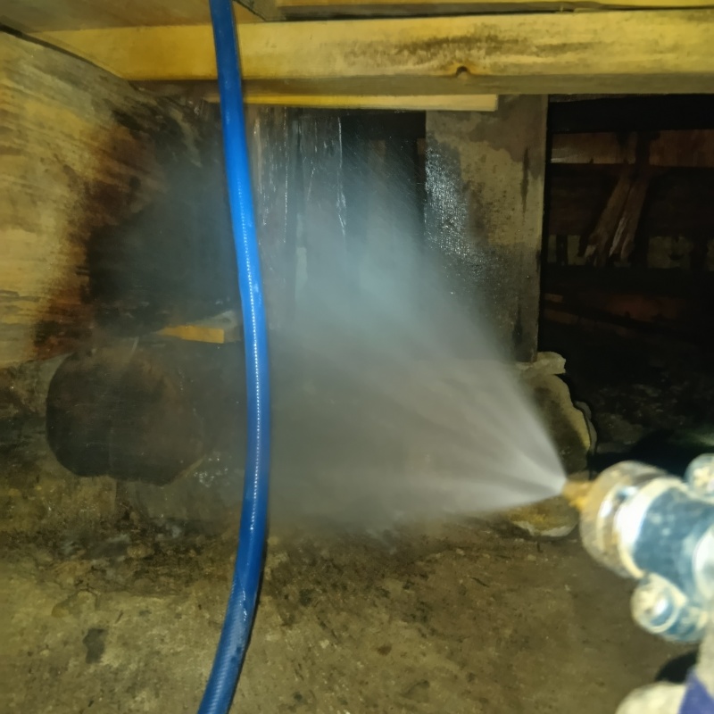 床下の木材にシロアリ駆除剤を散布する様子