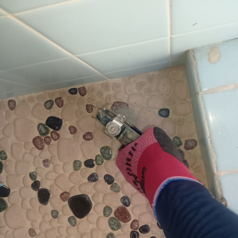 浴室の床にシロアリ駆除剤を注入する様子