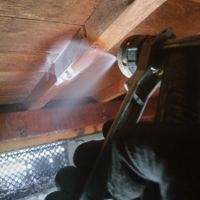 床下の木材にシロアリ駆除剤を散布する様子