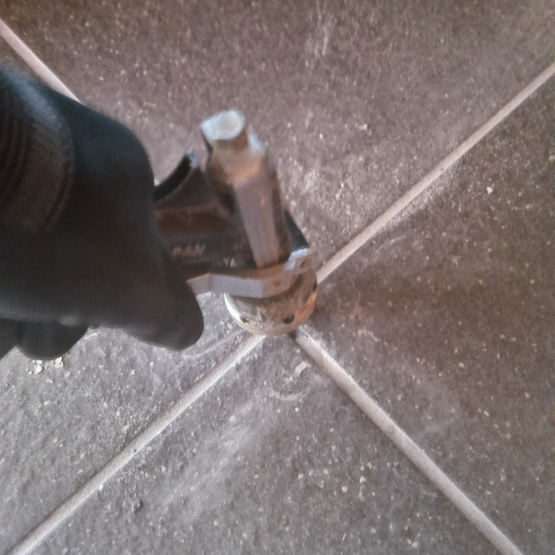 玄関の床にシロアリ駆除剤を注入する様子