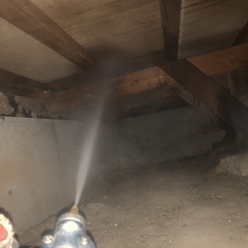 床下の木材にシロアリ駆除剤を散布する様子