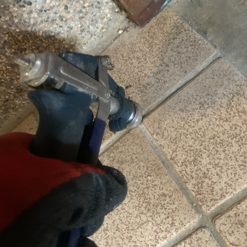 玄関の床にシロアリ駆除剤を注入する様子