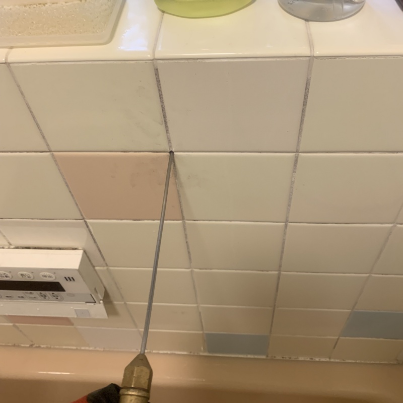 浴室の壁にシロアリ駆除剤を注入する様子