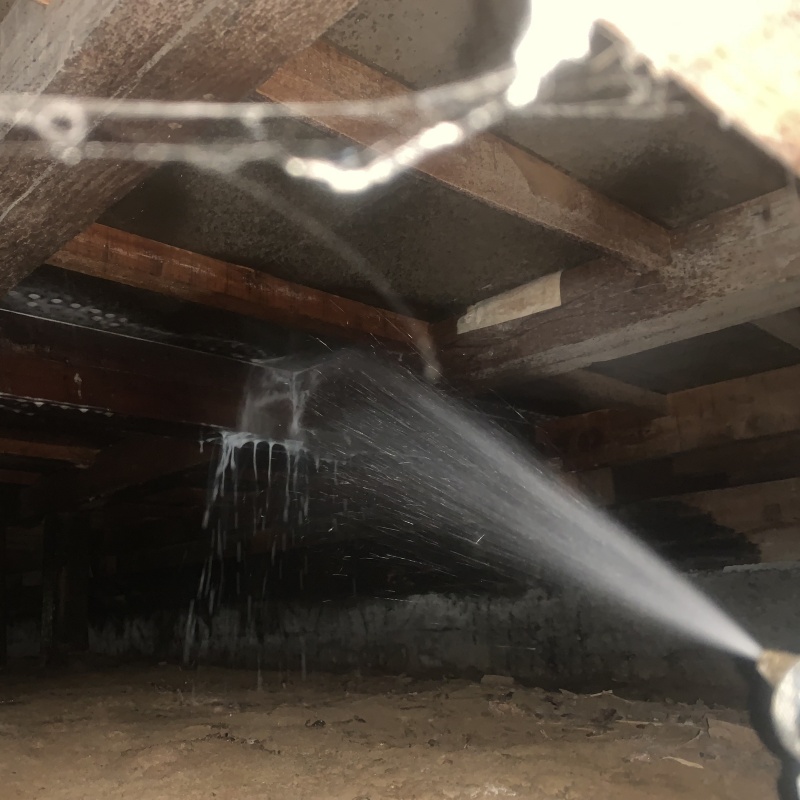 床下の木材にシロアリ駆除剤を散布する様子