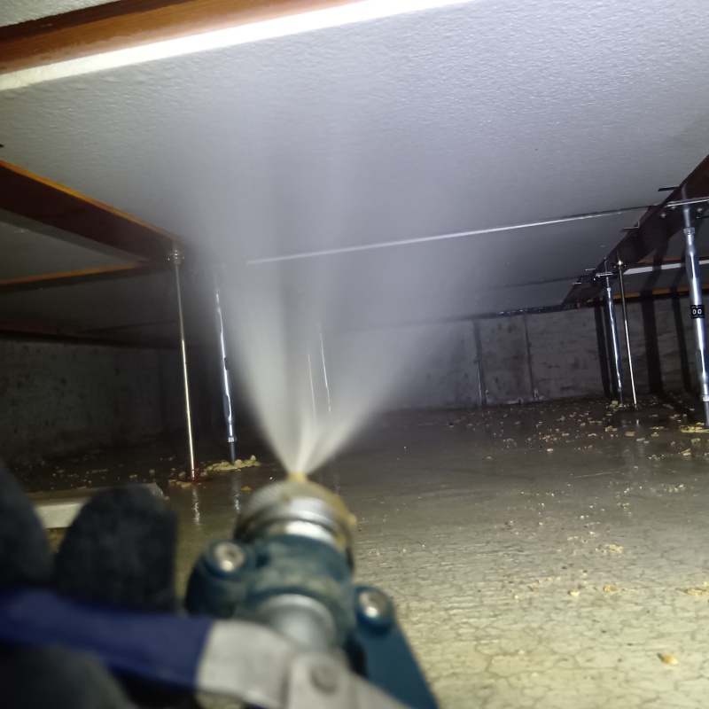 床下の断熱材に防蟻剤を散布する様子