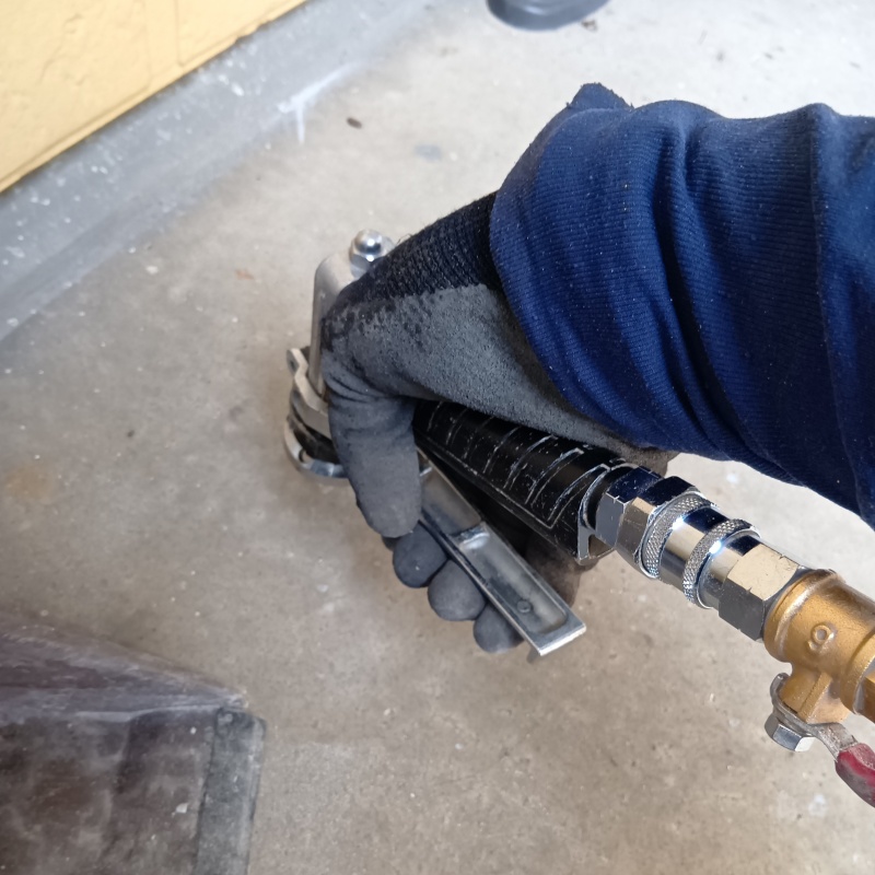 玄関の床にシロアリ駆除剤を注入する様子