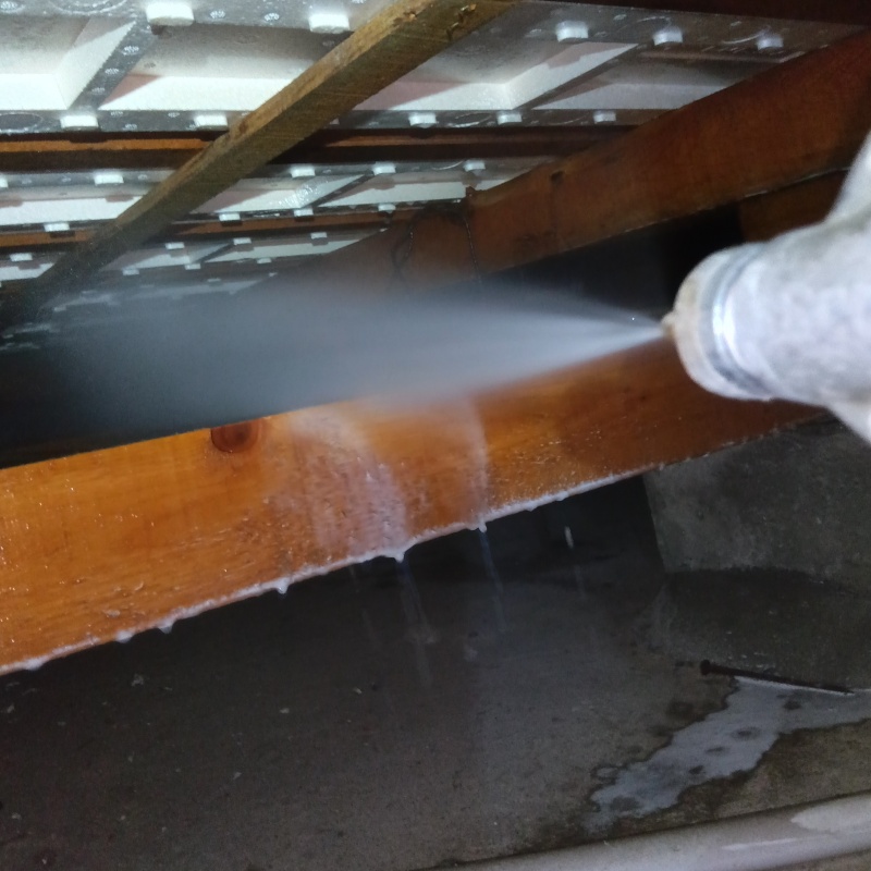 床下の木材にシロアリ駆除剤を散布する様子