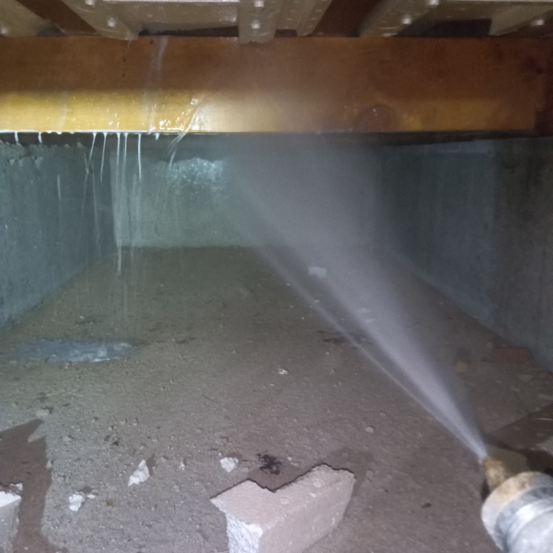 床下の木材にシロアリ駆除剤を散布する様子