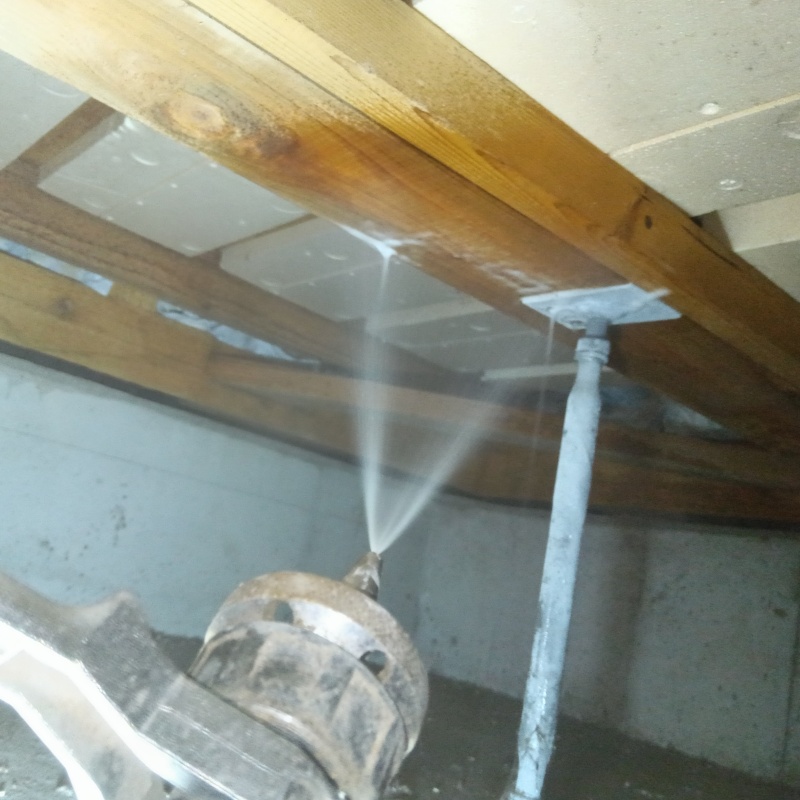 床下の木材にシロアリ駆除剤を散布する様子