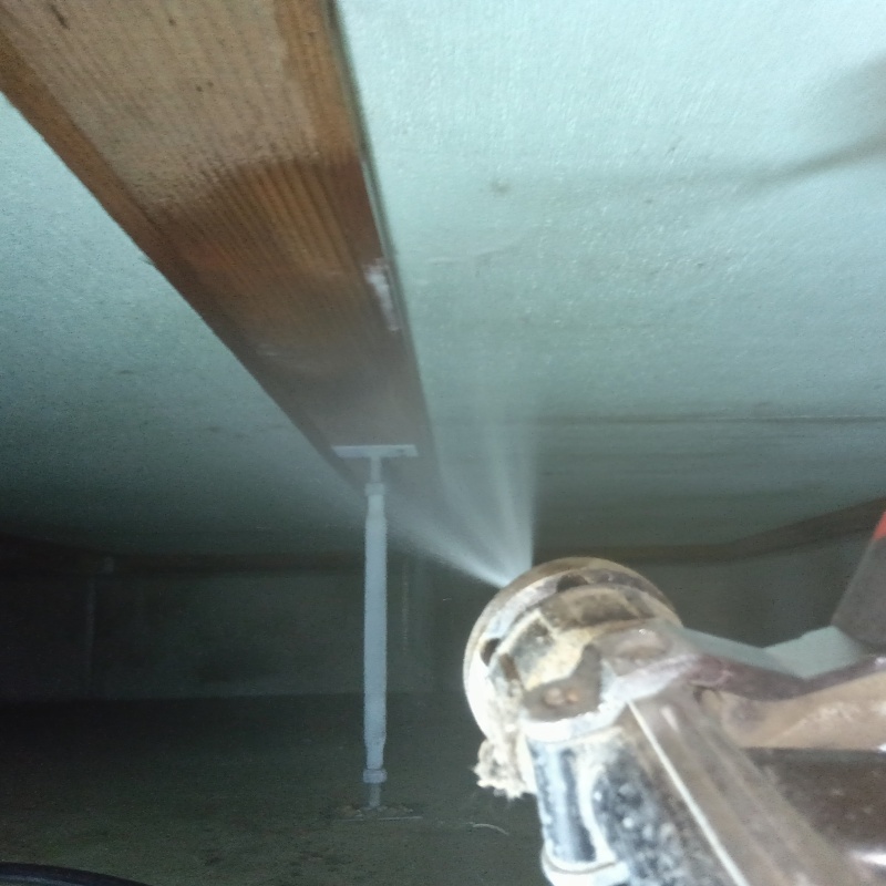 床下の木材にシロアリ駆除剤を散布する様子