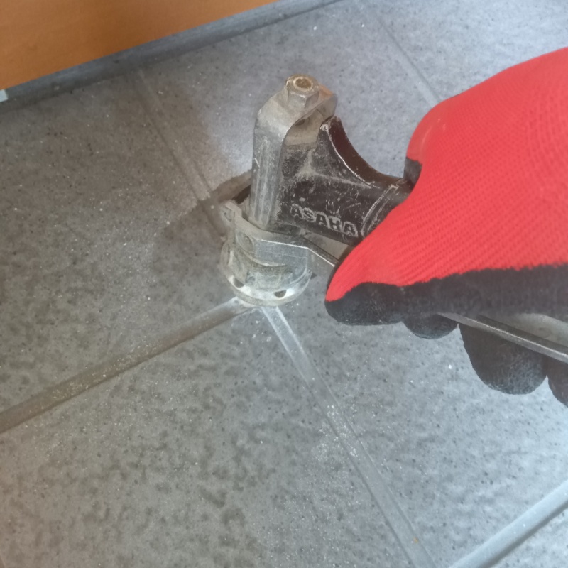 玄関の床にシロアリ駆除剤を注入する様子