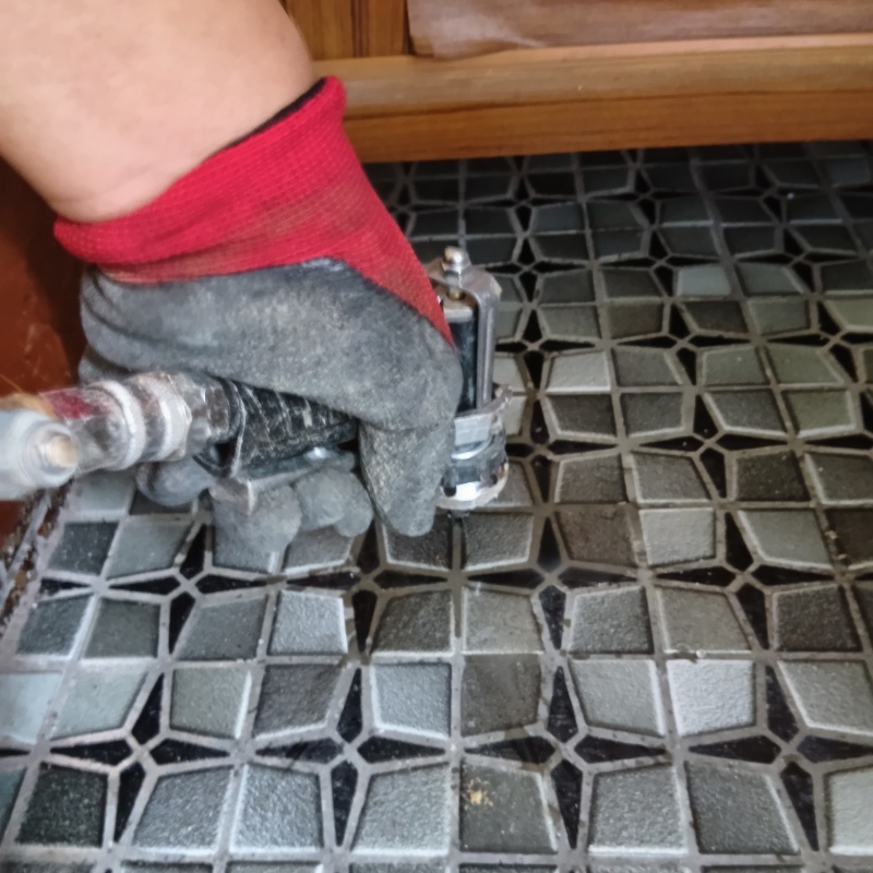 玄関の床にシロアリ駆除剤を注入する様子