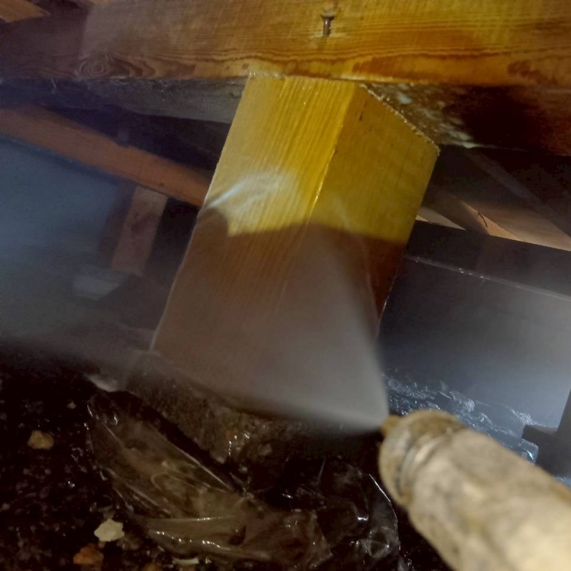 床下の木材にシロアリ駆除剤を散布する様子