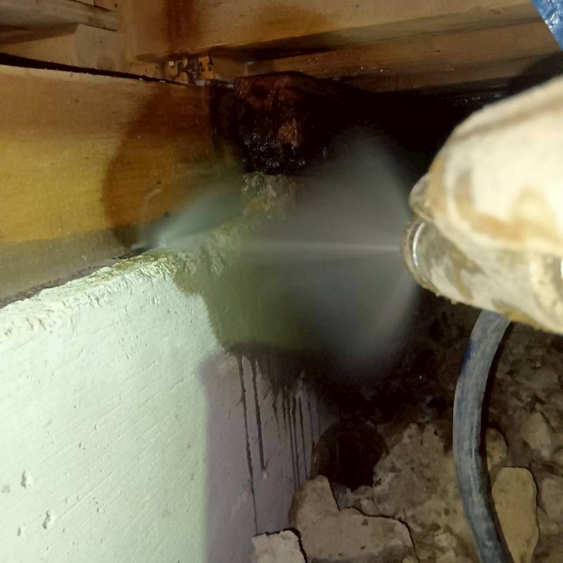 床下の木材にシロアリ駆除剤を散布する様子