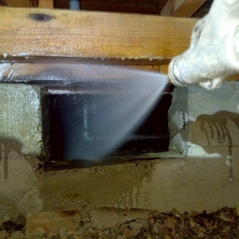 床下の基礎部分にシロアリ駆除剤を散布する様子